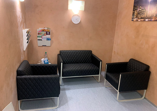 Praxisfahrzeug mit Team vor dem Gebaeude